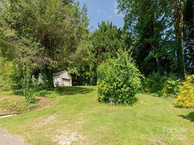 34 Lockhart Rd, Tryon, NC 28782 - view of green lawn featuring an outdoor structure and a garage