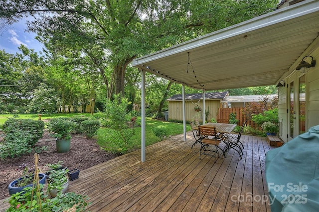 5211 Londonderry Rd, Charlotte, NC 28210 - deck with outdoor dining area, an outbuilding, view of scattered trees, and area for grilling