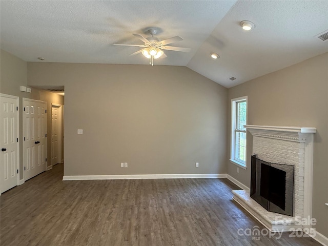 4402 Poxon Ln, Monroe, NC 28110 - unfurnished living room with a ceiling fan, lofted ceiling, dark wood-style floors, a brick fireplace, and a textured ceiling
