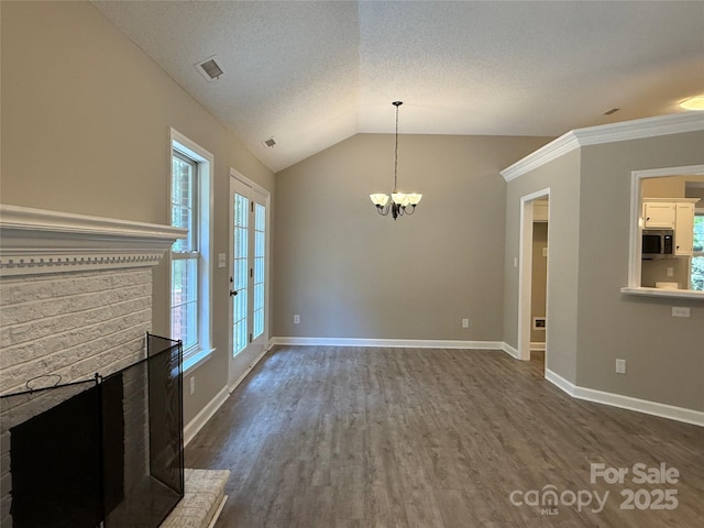 4402 Poxon Ln, Monroe, NC 28110 - unfurnished living room with plenty of natural light, dark wood-style floors, a chandelier, lofted ceiling, and a fireplace