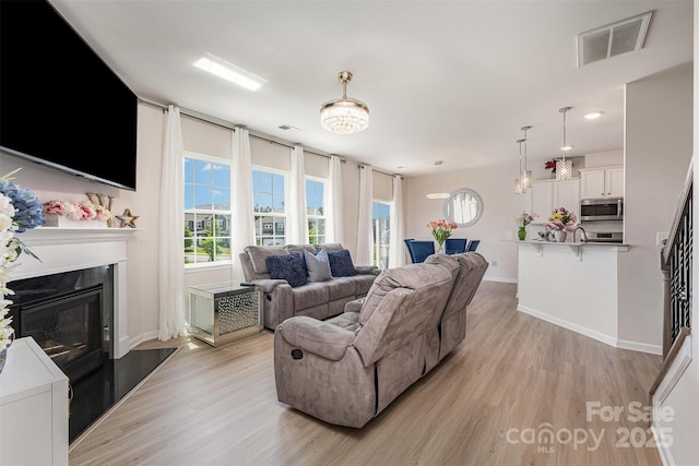 205 Falls Cove Dr, Troutman, NC 28166 - living room featuring light wood finished floors, a glass covered fireplace, and recessed lighting