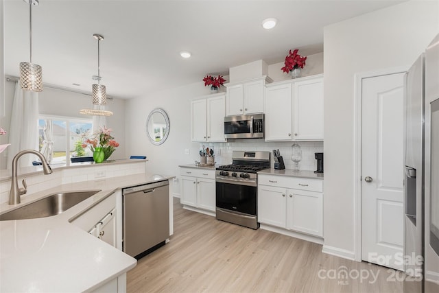 205 Falls Cove Dr, Troutman, NC 28166 - kitchen featuring appliances with stainless steel finishes, decorative backsplash, light wood-type flooring, light countertops, and white cabinets