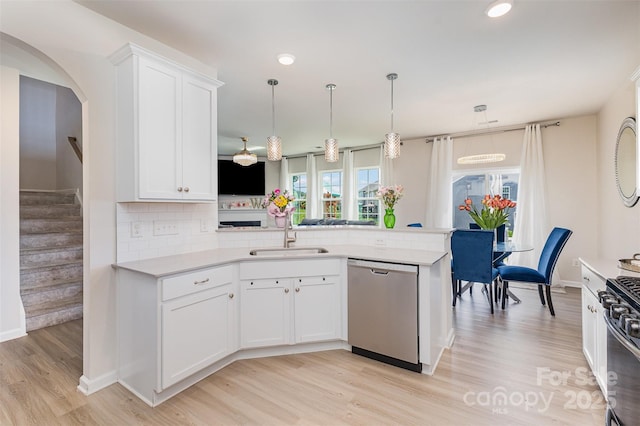 205 Falls Cove Dr, Troutman, NC 28166 - kitchen with stainless steel dishwasher, a peninsula, light wood-type flooring, light countertops, and decorative backsplash