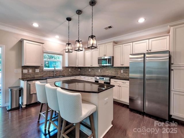 5797 Mcclintock Dr, Denver, NC 28037 - kitchen with stainless steel appliances, ornamental molding, a breakfast bar, dark countertops, and decorative backsplash