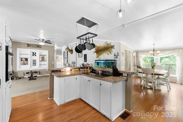 5425 Creek Run Ct, Kings Mountain, NC 28086 - kitchen with light wood-style flooring, white cabinets, black electric stovetop, a chandelier, and decorative light fixtures