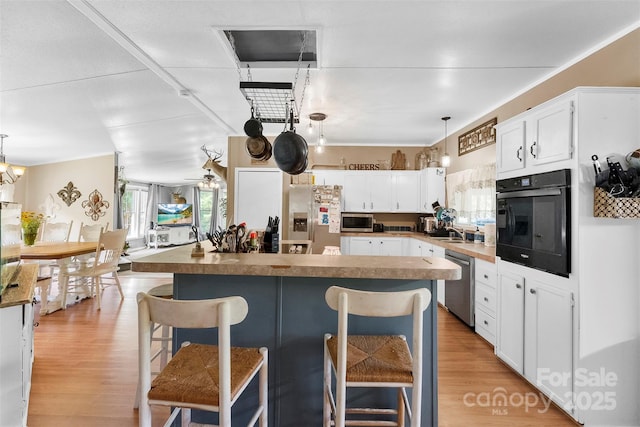5425 Creek Run Ct, Kings Mountain, NC 28086 - kitchen featuring appliances with stainless steel finishes, a breakfast bar, white cabinetry, and light wood-style flooring