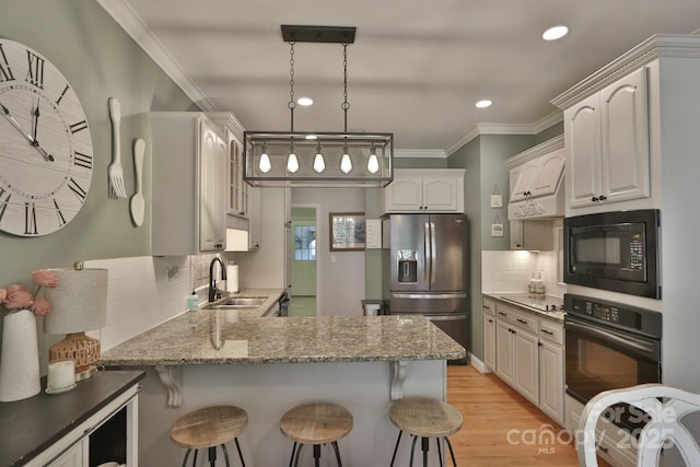 2400 Saint John Rd, East Bend, NC 27018 - kitchen featuring black appliances, a peninsula, a kitchen breakfast bar, light stone countertops, and ornamental molding