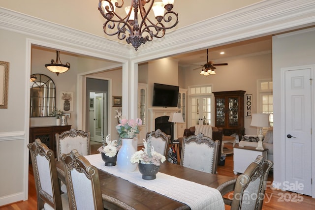 2400 Saint John Rd, East Bend, NC 27018 - dining space with wood finished floors, a fireplace, a chandelier, ceiling fan, and crown molding