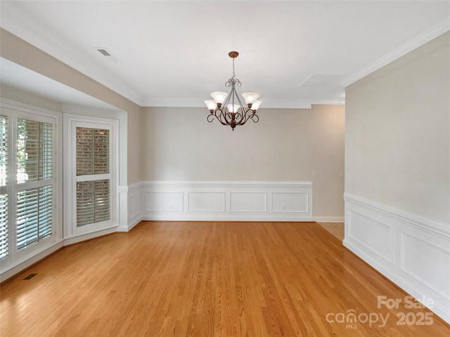 2027 Brook View Ct, Matthews, NC 28104 - unfurnished room featuring a chandelier, healthy amount of natural light, light wood-style floors, crown molding, and wainscoting