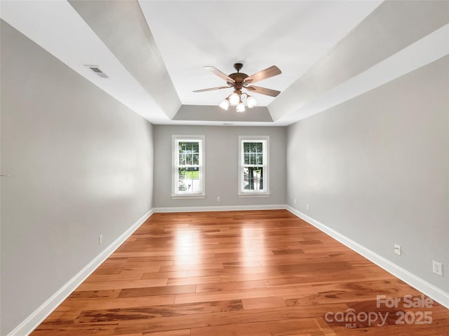 2027 Brook View Ct, Matthews, NC 28104 - unfurnished room featuring light wood-style flooring, ceiling fan, and a tray ceiling