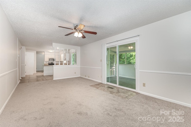 7008 Wannamaker Ln, Charlotte, NC 28226 - unfurnished living room with light colored carpet, a ceiling fan, a textured ceiling, and healthy amount of natural light