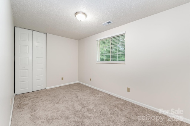 7008 Wannamaker Ln, Charlotte, NC 28226 - unfurnished bedroom featuring carpet flooring, a textured ceiling, and a closet