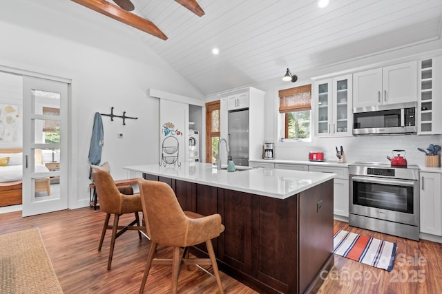 891 Crescent Trl Unit 273, Highlands, NC 28741 - kitchen featuring stainless steel appliances, light countertops, a breakfast bar area, washer / dryer, and wood finished floors