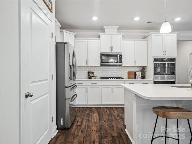 1008 Millbridge Pkwy, Waxhaw, NC 28173 - kitchen featuring stainless steel appliances, crown molding, dark wood-style floors, white cabinetry, and light countertops