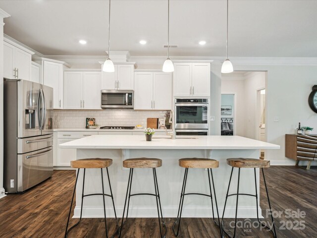 1008 Millbridge Pkwy, Waxhaw, NC 28173 - kitchen with stainless steel appliances, tasteful backsplash, white cabinetry, a kitchen breakfast bar, and crown molding