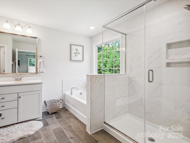 1008 Millbridge Pkwy, Waxhaw, NC 28173 - full bath with a garden tub, vanity, a shower stall, and wood tiled floors