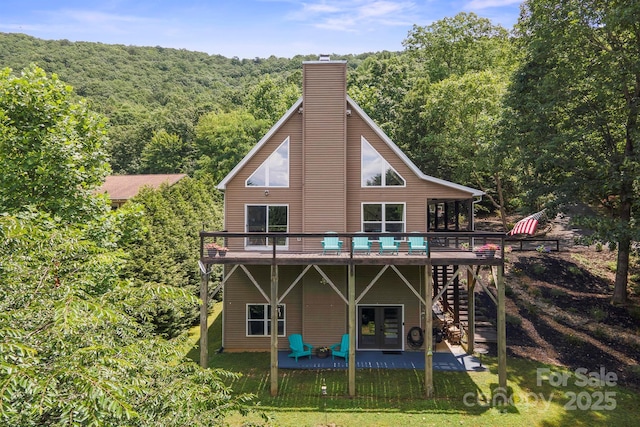 3381 Stones Throw Dr, Valdese, NC 28690 - back of property with a forest view, a wooden deck, a patio area, stairway, and a chimney