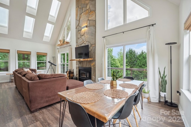 3381 Stones Throw Dr, Valdese, NC 28690 - dining area featuring high vaulted ceiling, a skylight, wood finished floors, plenty of natural light, and a stone fireplace