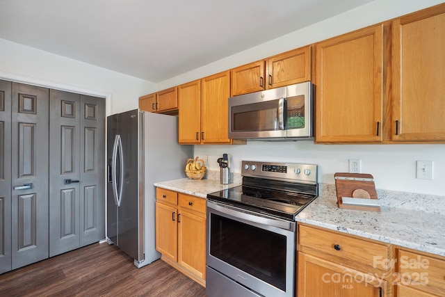 3381 Stones Throw Dr, Valdese, NC 28690 - kitchen with stainless steel appliances, dark wood-style flooring, light stone countertops, and brown cabinetry