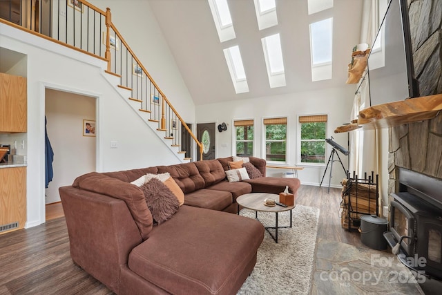 3381 Stones Throw Dr, Valdese, NC 28690 - living area with high vaulted ceiling, a skylight, stairs, dark wood-style floors, and a wood stove