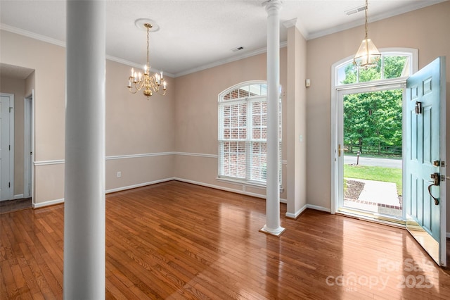 8002 Kingston Dr, Waxhaw, NC 28173 - entrance foyer featuring decorative columns, wood finished floors, ornamental molding, and a chandelier