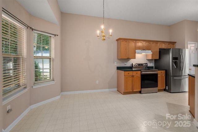 8002 Kingston Dr, Waxhaw, NC 28173 - kitchen with stainless steel appliances, a chandelier, under cabinet range hood, dark countertops, and hanging light fixtures