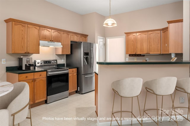 8002 Kingston Dr, Waxhaw, NC 28173 - kitchen with stainless steel appliances, under cabinet range hood, a breakfast bar, dark countertops, and a peninsula