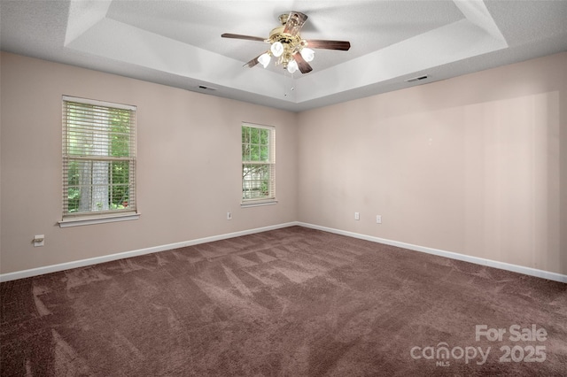 8002 Kingston Dr, Waxhaw, NC 28173 - spare room featuring a tray ceiling, carpet, and ceiling fan