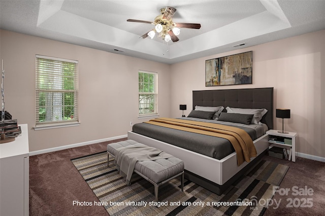 8002 Kingston Dr, Waxhaw, NC 28173 - carpeted bedroom featuring a tray ceiling and ceiling fan