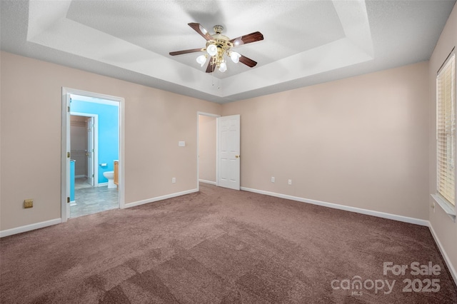 8002 Kingston Dr, Waxhaw, NC 28173 - unfurnished bedroom featuring a tray ceiling, carpet, ensuite bathroom, and ceiling fan