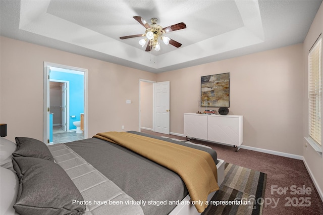 8002 Kingston Dr, Waxhaw, NC 28173 - bedroom with a tray ceiling, connected bathroom, carpet, and ceiling fan