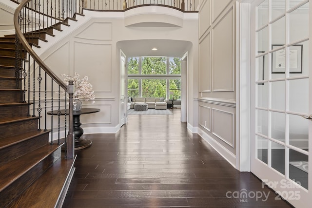 426 Kirkbride Ct, Fort Mill, SC 29715 - foyer entrance with a decorative wall, arched walkways, dark wood-type flooring, stairs, and a high ceiling
