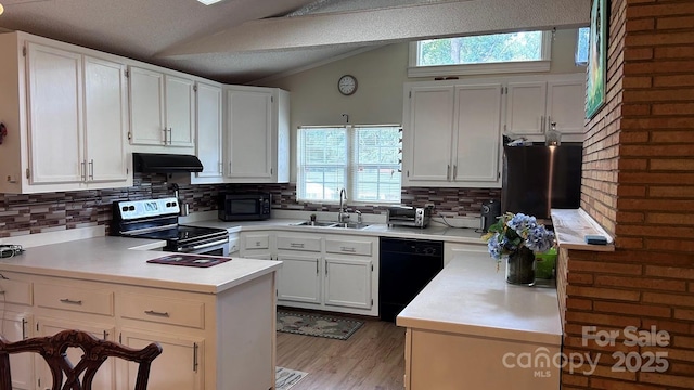 1010 Sprucewood St, Kannapolis, NC 28081 - kitchen with black appliances, lofted ceiling, a peninsula, decorative backsplash, and light countertops