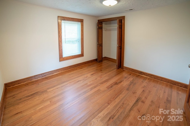 4879 Denton Chapel Rd, Morganton, NC 28655 - unfurnished bedroom with a textured ceiling, light wood-style flooring, and a closet
