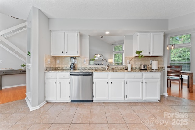 10043 Elsenham Ln, Charlotte, NC 28269 - kitchen with stainless steel dishwasher, white cabinetry, decorative backsplash, light stone counters, and a textured ceiling