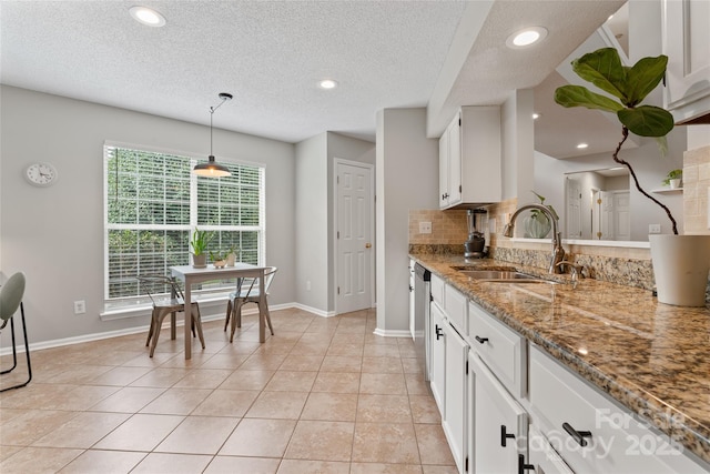 10043 Elsenham Ln, Charlotte, NC 28269 - kitchen with light stone countertops, white cabinetry, stainless steel dishwasher, backsplash, and recessed lighting