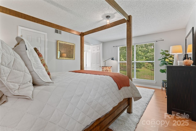 10043 Elsenham Ln, Charlotte, NC 28269 - bedroom with light wood finished floors and a textured ceiling