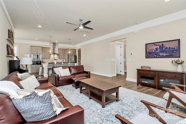 5129 Whitman Ave, Matthews, NC 28105 - living area with a ceiling fan, wood finished floors, recessed lighting, and crown molding