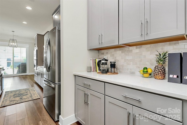 5129 Whitman Ave, Matthews, NC 28105 - kitchen featuring freestanding refrigerator, gray cabinetry, dark wood finished floors, light countertops, and tasteful backsplash