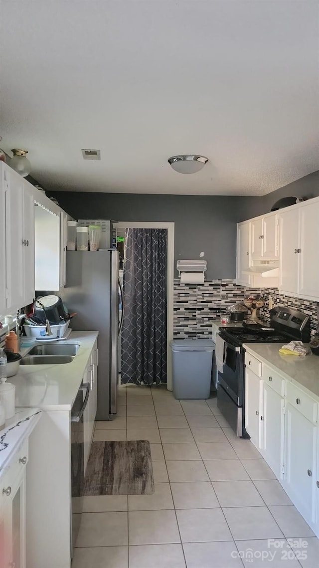 7401 Merrily Ln, Charlotte, NC 28214 - kitchen with stove, white cabinetry, light countertops, dishwasher, and light tile patterned floors
