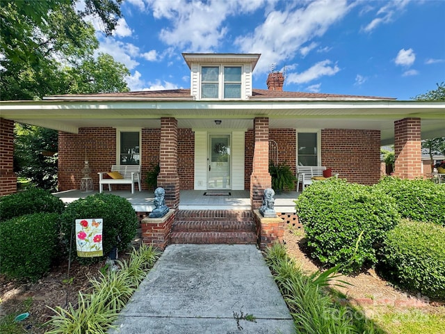 300 Blackmon St S, Bethune, SC 29009 - view of front of property featuring a porch, brick siding, and a chimney