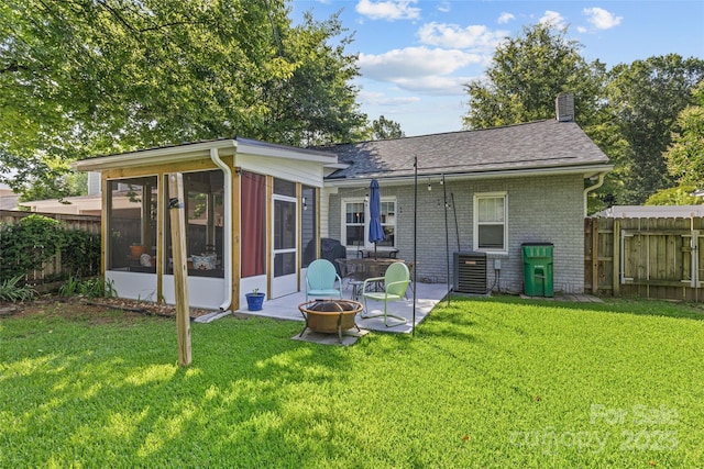 3035 Florida Ave, Charlotte, NC 28205 - back of property featuring a fire pit, a sunroom, a chimney, brick siding, and a shingled roof