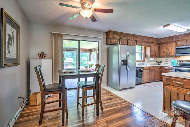 4004 Stillwater Ct, York, SC 29745 - kitchen featuring appliances with stainless steel finishes, a textured ceiling, brown cabinets, light countertops, and a ceiling fan