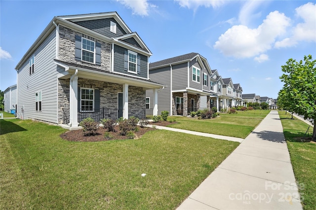 125 Cedar Knoll Cir, Pineville, NC 28134 - view of front of property with stone siding, covered porch, a front lawn, and a residential view