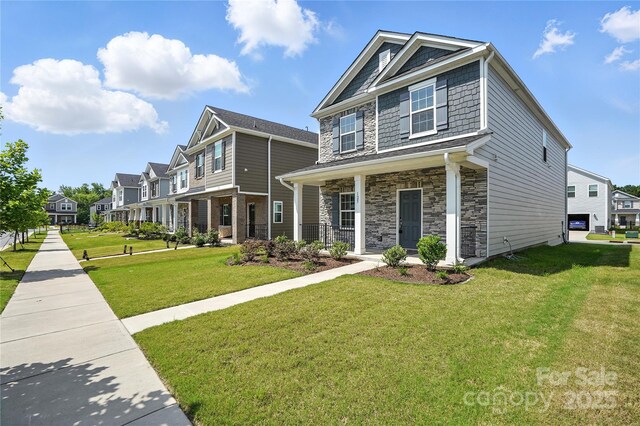 125 Cedar Knoll Cir, Pineville, NC 28134 - view of front of property featuring stone siding, a porch, a front lawn, and a residential view