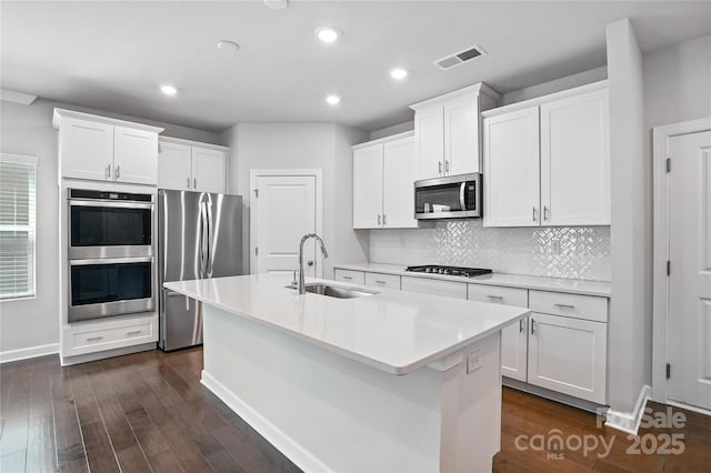 125 Cedar Knoll Cir, Pineville, NC 28134 - kitchen with stainless steel appliances, a center island with sink, dark wood-style floors, recessed lighting, and decorative backsplash