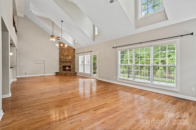 1812 Mill Chase Ln, Waxhaw, NC 28173 - unfurnished living room with ceiling fan, high vaulted ceiling, a skylight, a fireplace, and light wood-type flooring
