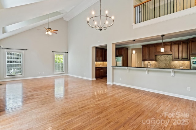 1812 Mill Chase Ln, Waxhaw, NC 28173 - kitchen featuring appliances with stainless steel finishes, high vaulted ceiling, dark countertops, a breakfast bar, and light wood-style floors