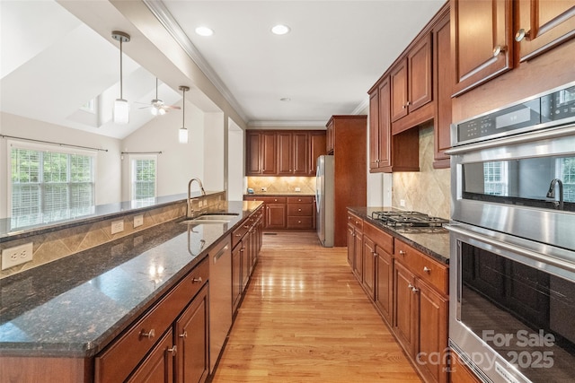 1812 Mill Chase Ln, Waxhaw, NC 28173 - kitchen featuring stainless steel appliances, ceiling fan, light wood-style floors, backsplash, and brown cabinetry