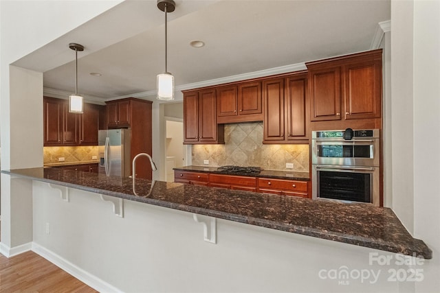 1812 Mill Chase Ln, Waxhaw, NC 28173 - kitchen with appliances with stainless steel finishes, a kitchen breakfast bar, backsplash, decorative light fixtures, and crown molding